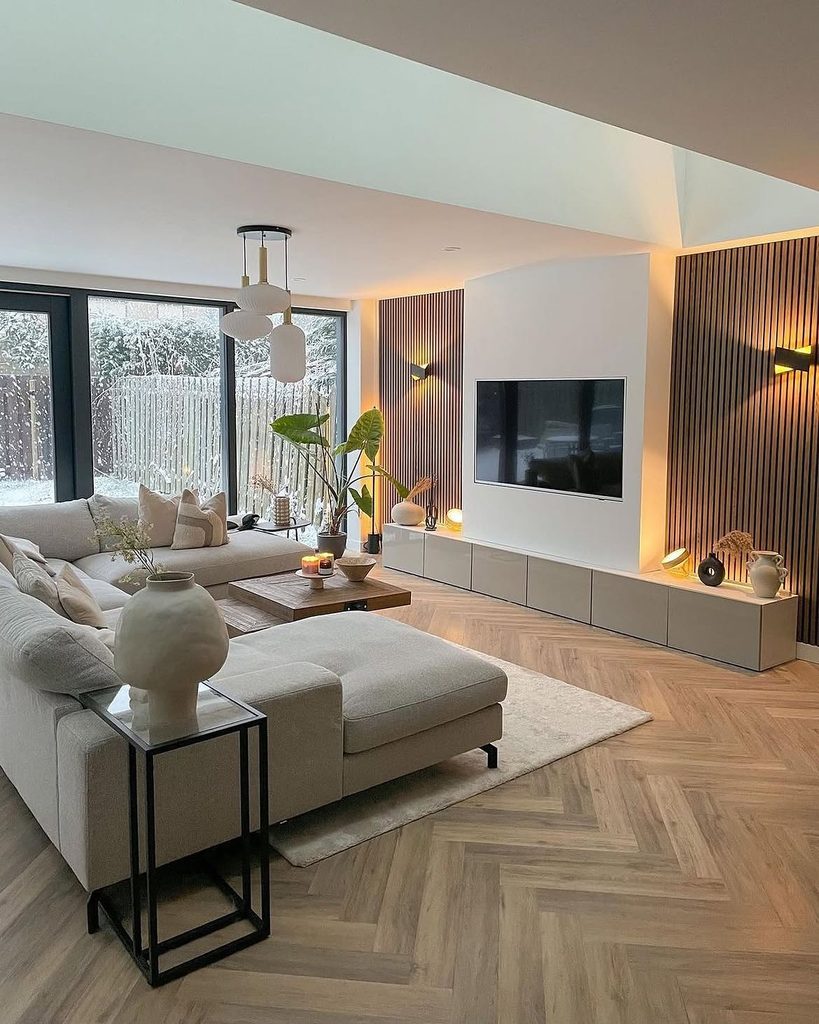 Living room with herringbone oak floor, slatted wood TV wall, and cream sectional sofa